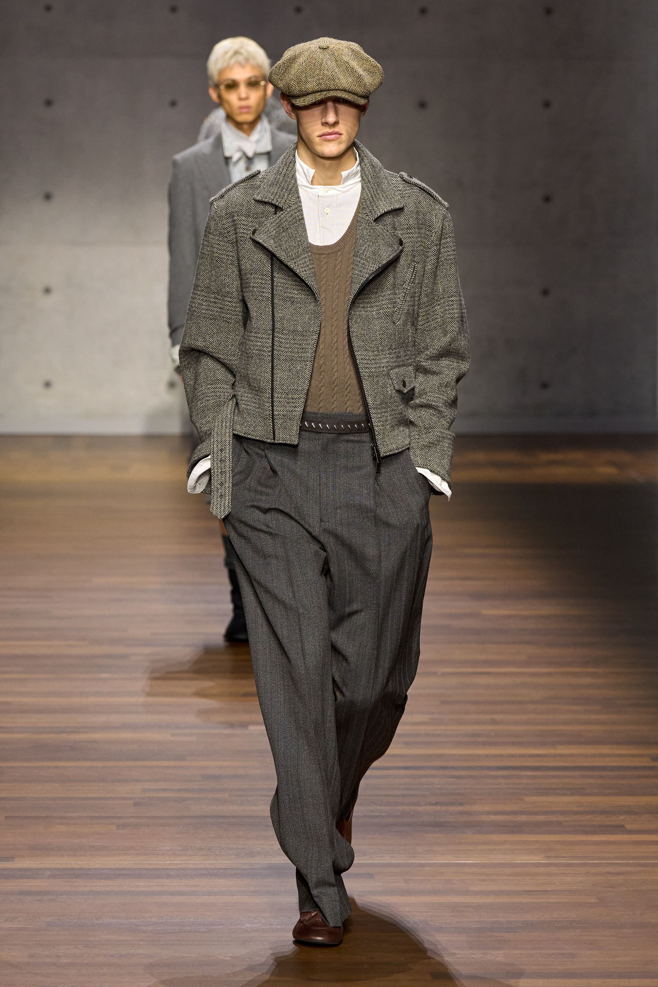 Emporio Armani在宽松西装与复古皮革夹克之间回溯品牌经典，以柔和灰棕与深蓝为基调，强调轻盈结构与舒适比例，复古绅士气质在当代语境中焕发出理性优雅-顽石频道趋势研究